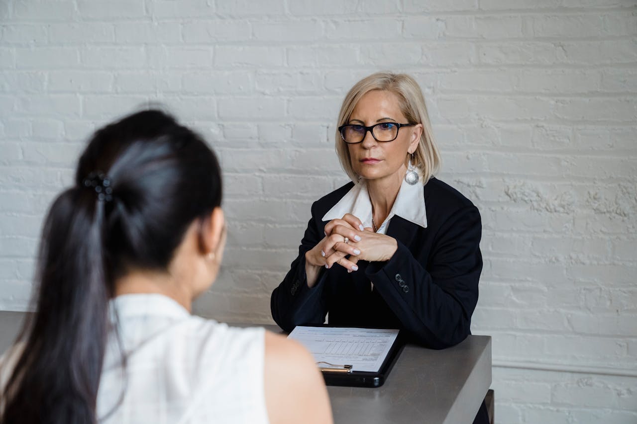 Professional businesswoman in a black blazer conducting an interview indoors.